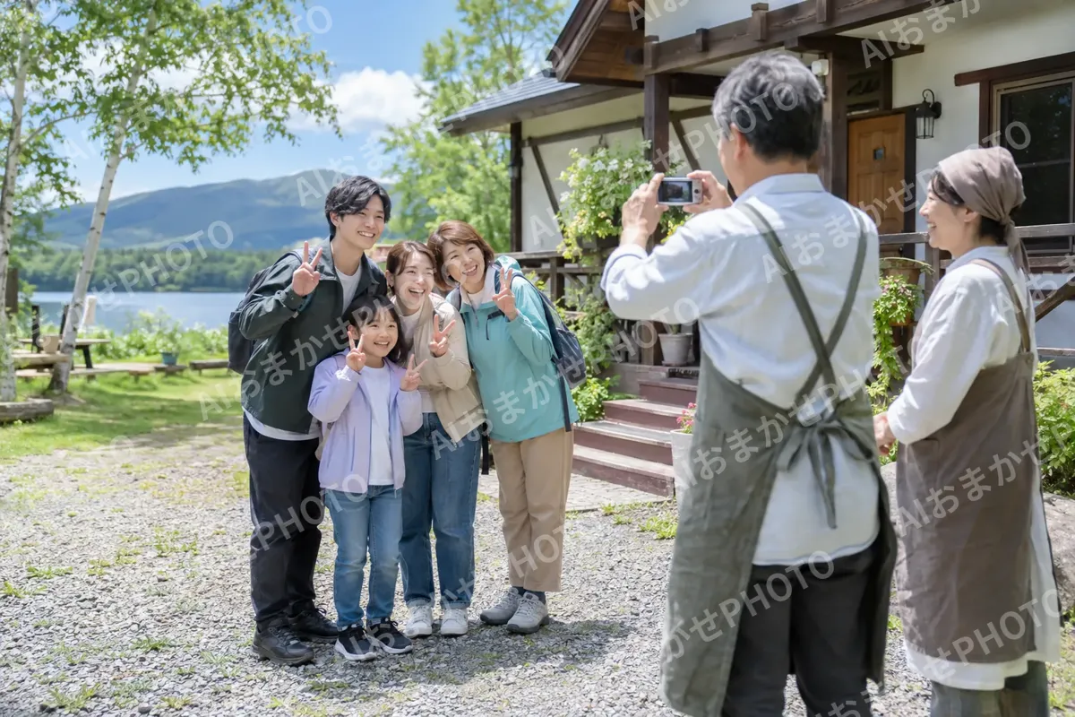 お客様と記念の写真を撮るオーナーの夫婦（ペンション・コテージの写真 No.32）