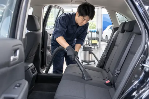 車内に掃除機をかけるスタッフ（洗車・カーコーティングの写真 No.35）