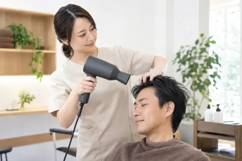 ドライヤーでお客様の髪をかわかすスタッフ（育毛・発毛・薄毛ケアの写真 No.34）