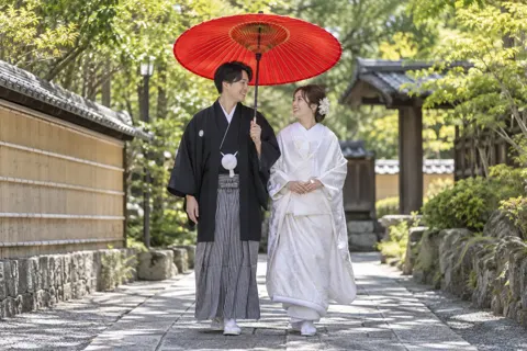 番傘をさして歩く和装の2人（フォトウェディング・前撮りの写真 No.22）