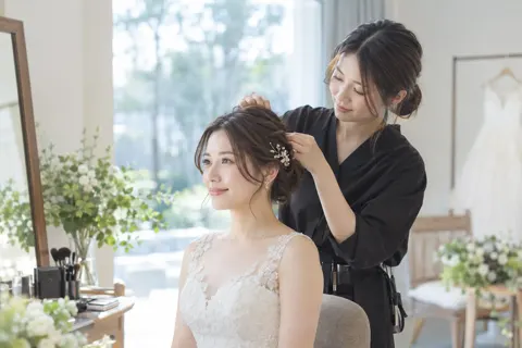 新婦の髪を整えるヘアメイクのスタッフ（フォトウェディング・前撮りの写真 No.27）