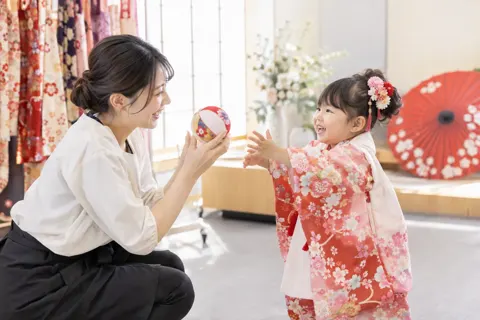 おもちゃを持って子どもをあやすスタッフ（成人式・七五三の写真 No.28）