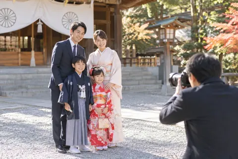 着物の子どもと家族の記念写真を撮るカメラマン（成人式・七五三の写真 No.29）