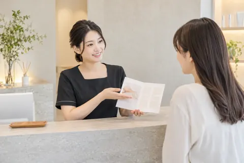受付で回数券の説明をするスタッフ（その他の美容・サロン（よもぎ蒸し・ヘッドスパ等）の写真 No.45）