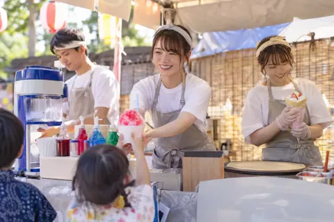 夏祭りの屋台でかき氷とクレープを売る店員たち（アイス・クレープ・かき氷の写真 No.25）