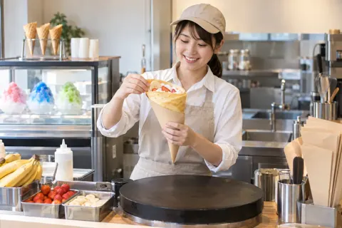 焼いたクレープを包み紙に入れる店員（アイス・クレープ・かき氷の写真 No.26）