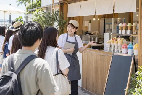 甘味の店の前の行列に声をかける店員（アイス・クレープ・かき氷の写真 No.27）