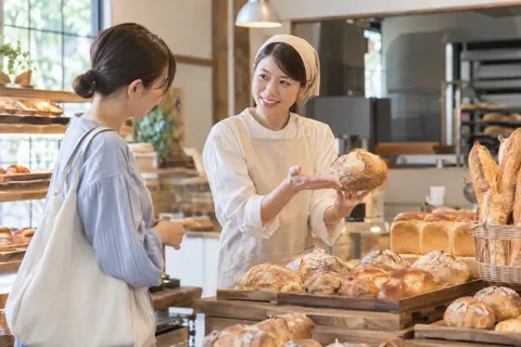 パンの種類を説明する店員とお客様（パン・ベーカリーの写真 No.34）