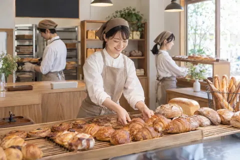 朝の開店に合わせてパンをならべる店員たち（パン・ベーカリーの写真 No.36）