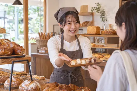 試食のパンをすすめる店員（パン・ベーカリーの写真 No.43）
