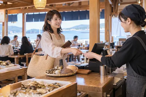 浜焼きの店のレジで貝の代金を払うお客様（浜焼きの写真 No.21）