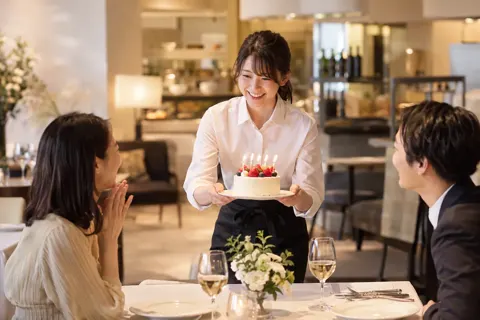 誕生日のケーキを運ぶスタッフ（イタリアン・フレンチの写真 No.28）
