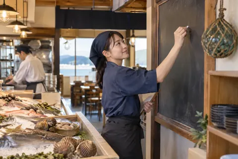 その日の魚を黒板に書く店員（海鮮丼・浜焼きの写真 No.20）