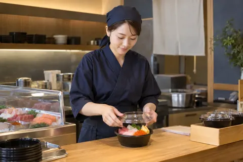 持ち帰りの海鮮丼にふたをする店員（海鮮丼の写真 No.20）