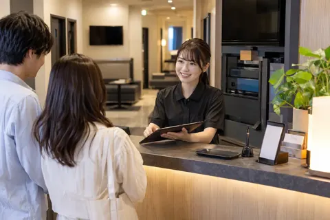 カラオケの受付で会員の手続きをする店員（カラオケ・カラオケボックスの写真 No.34）