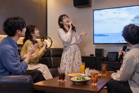 画面の歌詞を見ながら歌うお客様（カラオケ・カラオケボックスの写真 No.44）