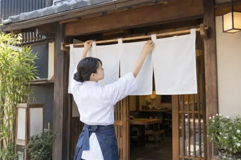 開店前にそば屋ののれんをかける店員（そば・うどんの写真 No.23）