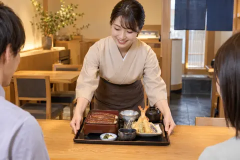 天ぷらとうなぎのお膳を出す店員（天ぷら・うなぎの写真 No.27）