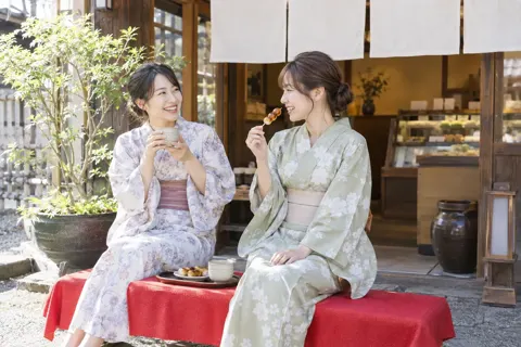 店先の縁台でお茶と団子を楽しむ二人（和菓子・団子・せんべいの写真 No.20）