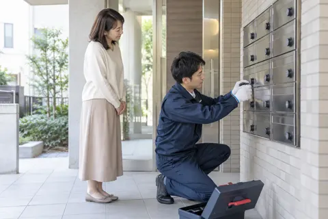 郵便受けのダイヤル錠を交換する技術者（鍵・防犯の写真 No.41）