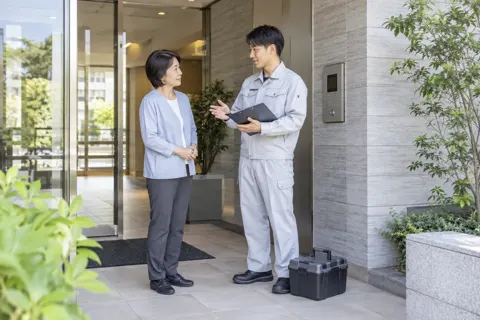 マンションの管理人と話す技術者（鍵・防犯の写真 No.45）