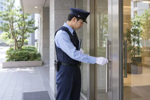ドアのかぎを確かめる警備員（警備・セキュリティの写真 No.19）