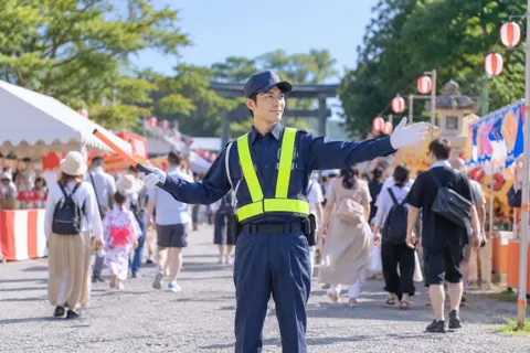 お祭りの会場で通路を案内する警備員（警備・セキュリティの写真 No.24）