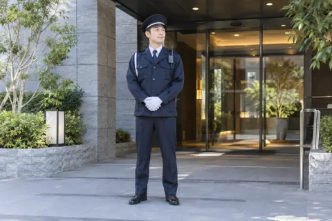 マンションのエントランスに立つ警備員（警備・セキュリティの写真 No.42）