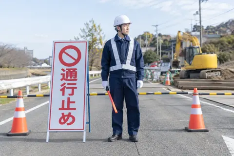 通行止めの看板のそばに立つ警備員（警備・セキュリティの写真 No.52）