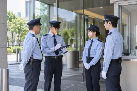 交代で申し送りをする警備員たち（警備・セキュリティの写真 No.56）
