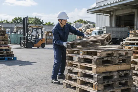 古いパレットを積み上げる作業員（産業廃棄物・収集運搬の写真 No.55）