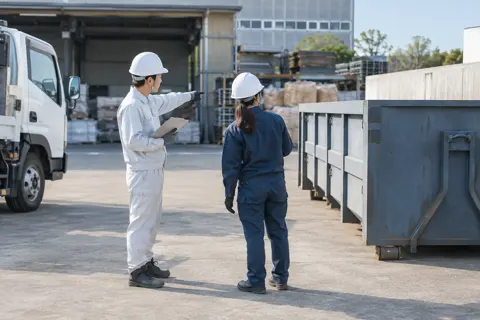 お客様の現場でコンテナの置き場所を決める社員（産業廃棄物・収集運搬の写真 No.68）