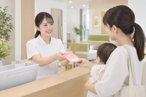 受付で母子手帳を受け取るスタッフ（小児科・産婦人科・レディースの写真 No.21）