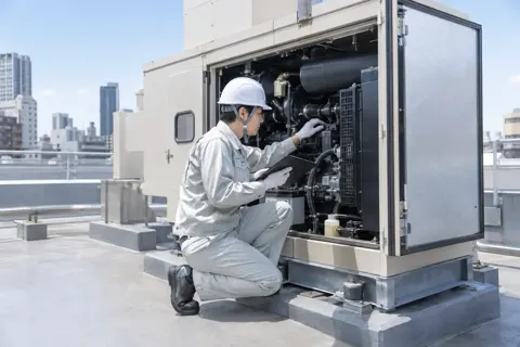 ビルの非常用の発電機を点検する電気工事士（電気工事・空調・電気設備の写真 No.50）