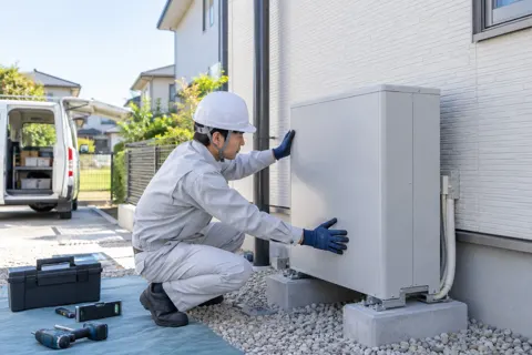 蓄電池を家の外にすえつける作業員（電気工事・空調・電気設備の写真 No.59）