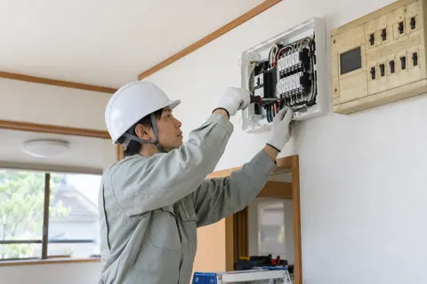 古い分電盤を新しいものに取りかえる電気工事士（電気工事・空調・電気設備の写真 No.66）