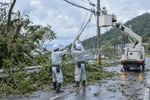 台風のあとに切れた電線を直す作業員たち（電気工事・空調・電気設備の写真 No.68）