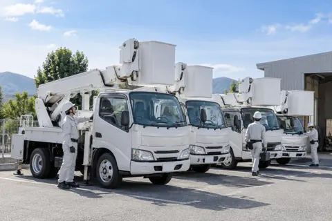 高所作業車が並んだ会社の駐車場（電気工事・空調・電気設備の写真 No.71）