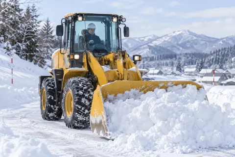 雪の中で除雪の重機を動かすオペレーター（土木・解体・基礎・造成の写真 No.63）