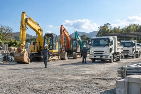 資材置き場に並んだ重機と会社のトラック（土木・解体・基礎・造成の写真 No.69）