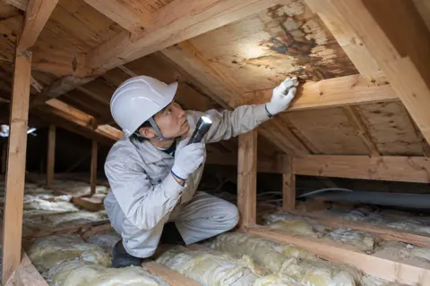 雨漏りの場所を天井裏で調べる職人（外壁・屋根・塗装・防水の写真 No.63）