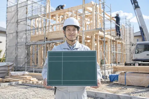 現場の黒板を持って写真をとる現場監督（建築・建設その他の写真 No.42）