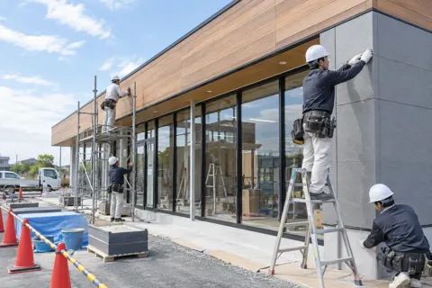 店舗の建設で外装を仕上げる作業員たち（総合建設・ビル・マンション・店舗・工場の写真 No.45）