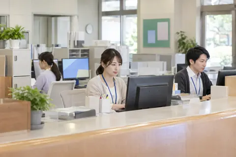 窓口の奥でパソコンに入力する職員たち（行政・公共・団体・組合の写真 No.23）