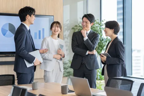 会議が終わって笑顔で立ち話をする人たち（経営・各種コンサルの写真 No.23）