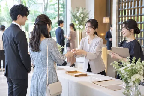 パーティーの受付で参加者を迎えるスタッフ（結婚相談所・婚活の写真 No.20）