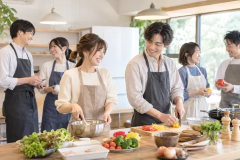 料理をしながら交流するイベントの参加者たち（結婚相談所・婚活の写真 No.22）