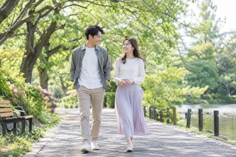 公園を並んで歩く二人（結婚相談所・婚活の写真 No.27）