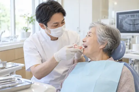 入れ歯を合わせる歯科医師とお年寄りの患者さん（歯科の写真 No.34）