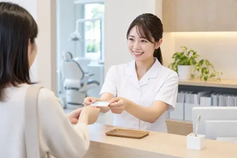 受付で診察券を受け取るスタッフ（歯科の写真 No.43）